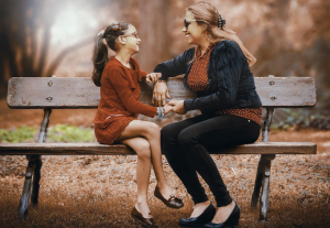 mother and daughter sitting on a bench