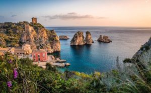 Pastel houses on a cliff above the sea in Italy